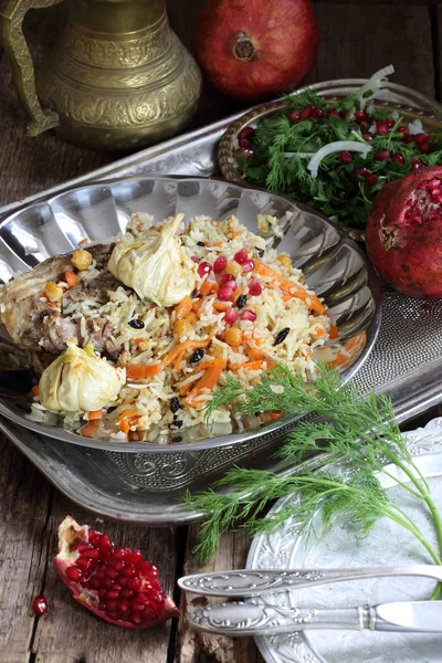 Mesa festiva espera pilaf uzbeko con carne y garbanzos —  Fotos de Stock