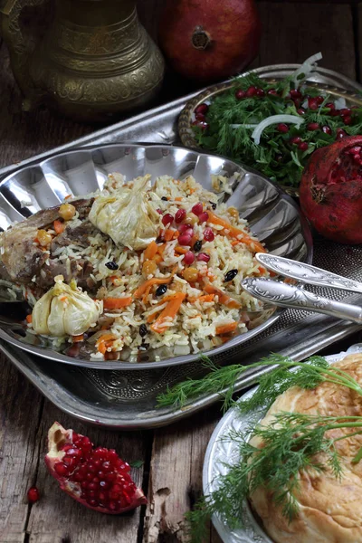 pilaf with meat, carrots and chickpeas served with pomegranate a