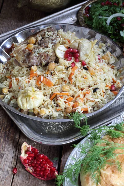 Pilaf with meat, chickpeas and carrots on a wooden table — Stock Photo, Image