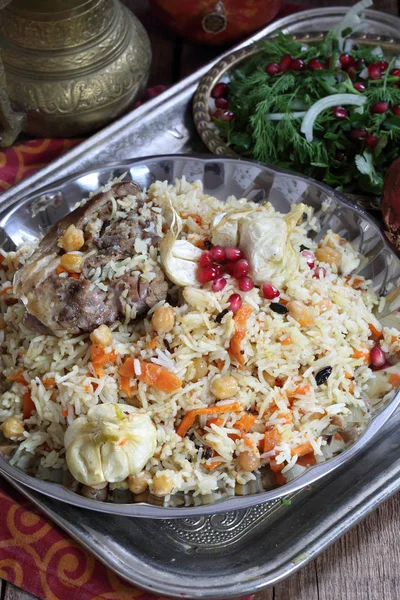 Pilaf with meat, chickpeas and carrots on a wooden table — Stock Photo, Image