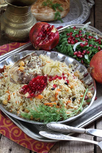 Pilaf with meat, chickpeas and carrots on a wooden table — Stock Photo, Image