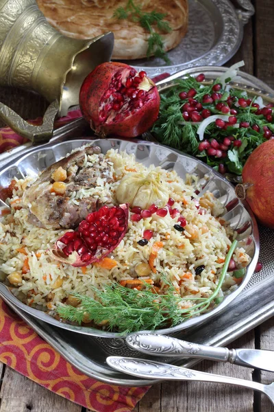 Pilaf with meat, chickpeas and carrots on a wooden table — Stock Photo, Image