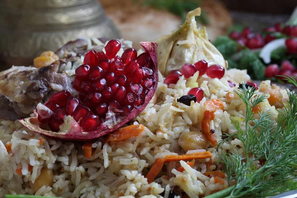 Pilaf with meat, chickpeas , carrots and pomegranate — Stock Photo, Image