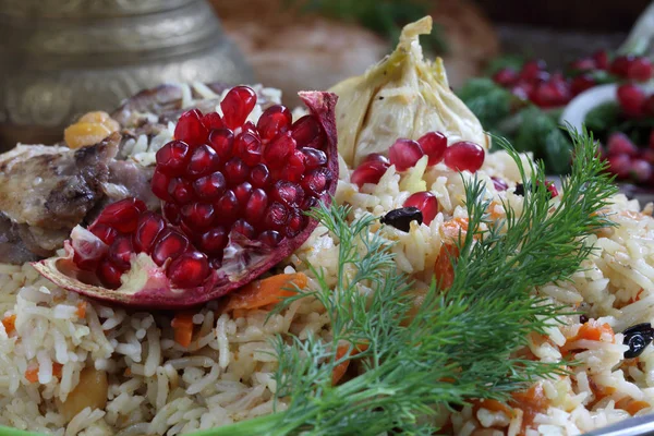 Pilaf with meat, chickpeas , carrots and pomegranate — Stock Photo, Image