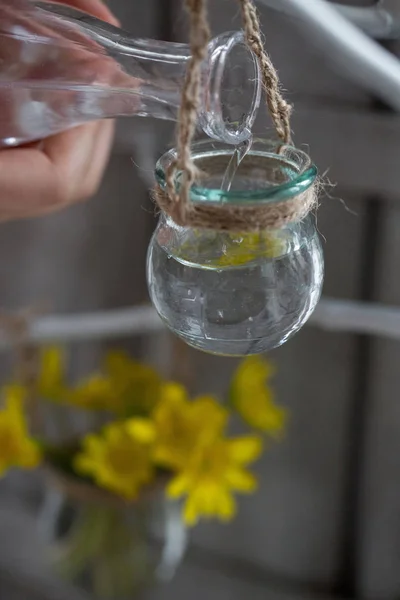 Acqua della mano del bambino dalla bottiglia trasparente versata in un vaso di vetro — Foto Stock