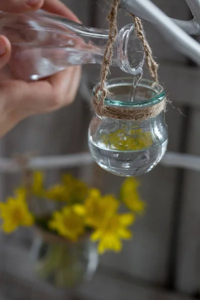 Acqua della mano del bambino dalla bottiglia trasparente versata in un vaso di vetro — Foto Stock