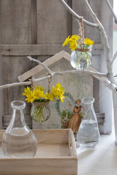 Yellow spring flowers in a little glass vase — Stock Photo, Image
