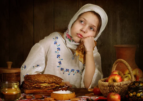 Ragazza mangiare frittelle al tavolo delle vacanze — Foto Stock