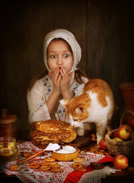 Девушка с рыжим котом за праздничным столом — стоковое фото