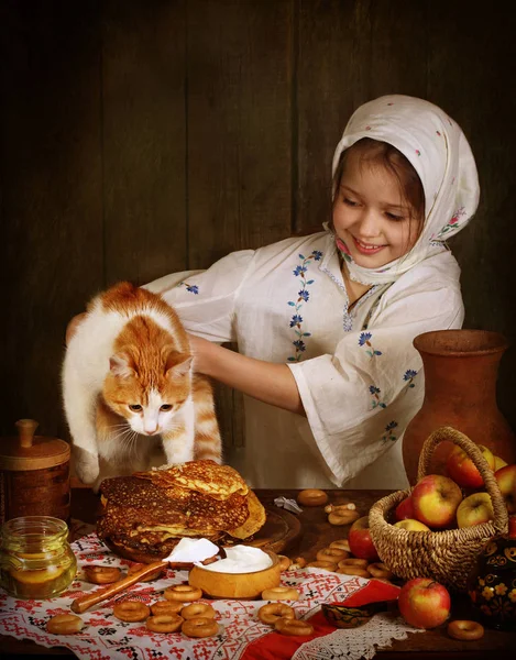 A menina com o gato vermelho para a mesa de férias — Fotografia de Stock