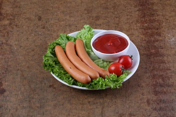 Sausage on salad with ketchup — Stock Photo, Image