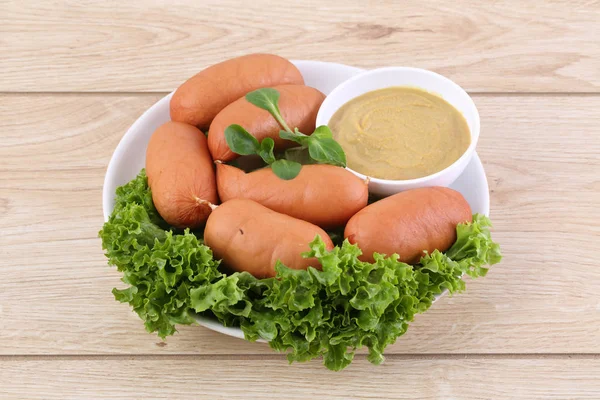 Sausages on lettuce with mustard and rucola — Stock Photo, Image