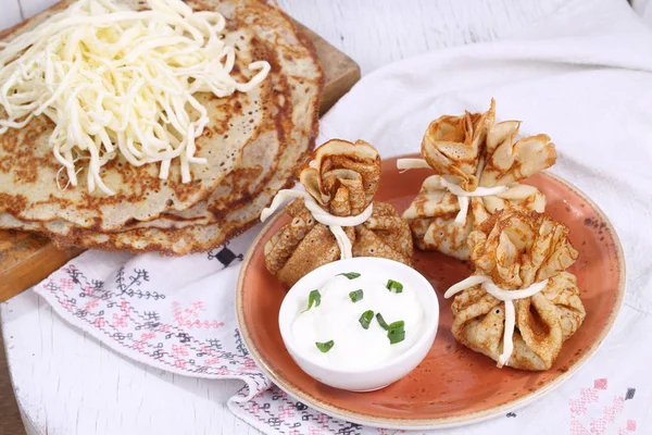 Sacchetti di pancake con carne su uno sfondo di legno bianco — Foto Stock