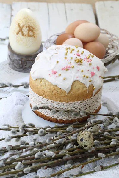 Easter cake with colored eggs and willow twigs on a wooden table — Stok fotoğraf