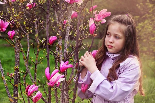 Dziewczyna w purpurę, w pobliżu drzewa kwitnące Magnolia — Zdjęcie stockowe