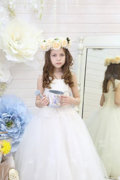 Chica regando flores con una pequeña regadera — Foto de Stock