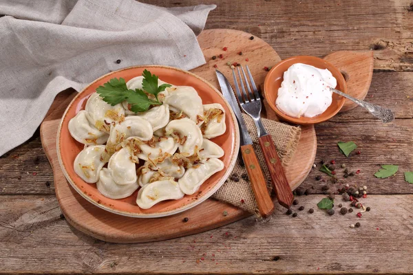 Dumplings con patatas y cebollas fritas en un tazón de cerámica — Foto de Stock