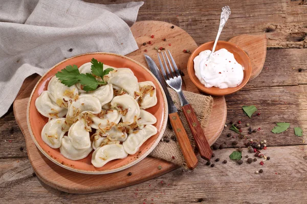 Dumplings con patatas y cebollas fritas en un tazón de cerámica —  Fotos de Stock