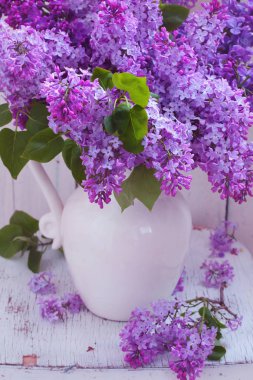 Beyaz bir vazo içinde pembe orman peonies