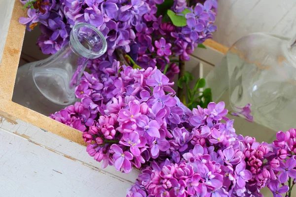 Lila. Kytice fialová v bílé krabice a skleněná váza — Stock fotografie