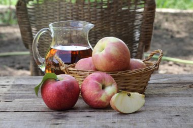 Elma. Ahşap bir masa üzerinde bir hasır sepet içinde taze elma 