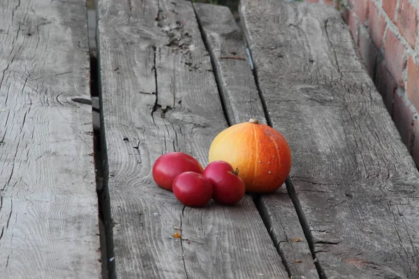 Calabaza y tomates. calabaza naranja, y tomates en una ta de madera — Foto de Stock