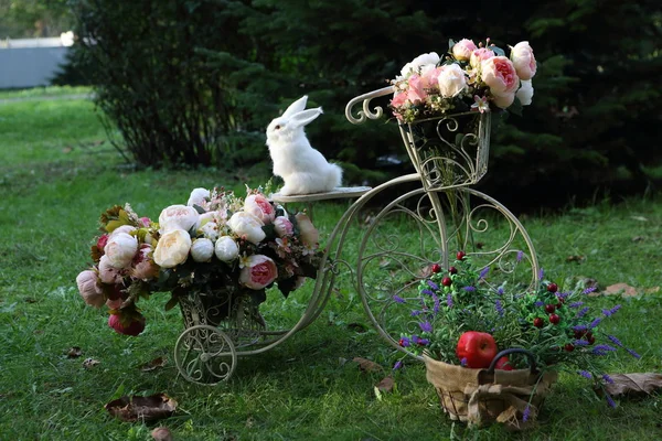 A bouquet of roses and a white rabbit on the carved table — Stock Photo, Image