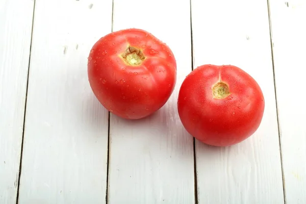 Tomates maduros em uma mesa de madeira — Fotografia de Stock