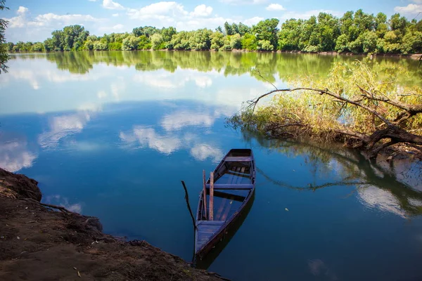 Un viejo bote de madera lleno de agua en el río — Foto de Stock