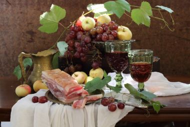 şarap, üzüm ve ahşap bir masa üzerinde tuzlu pastırma ile natürmort