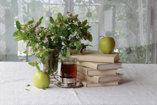 Böcker, kopp te och en bukett av Kaprifol blommar — Stockfoto