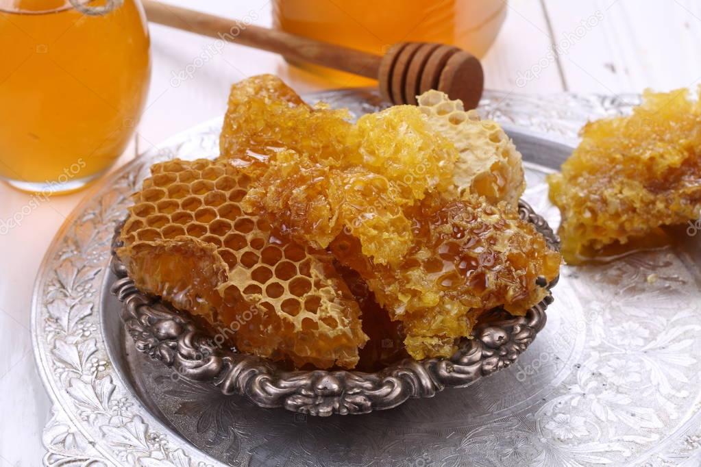 Honey comb on a white wooden background