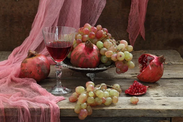 Stilleben med rödvin, rosa druvor och granatäpple — Stockfoto