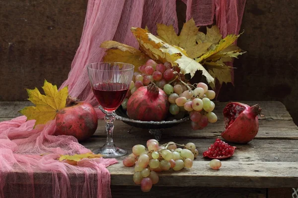 Ainda vida com vinho tinto, folhas de outono, uvas e romã — Fotografia de Stock