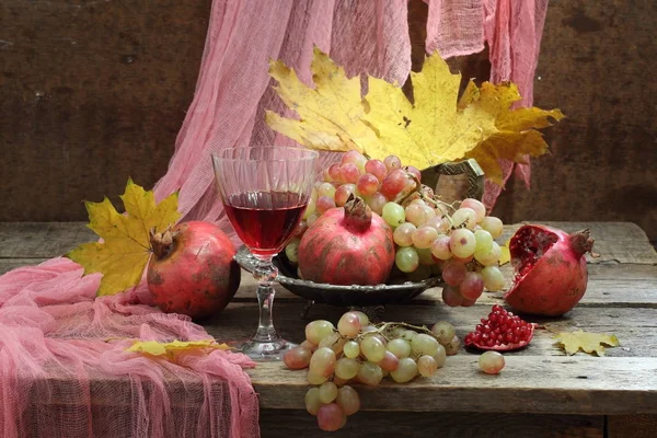 Nature morte avec vin rouge, feuilles d'automne, raisins et grenade — Photo