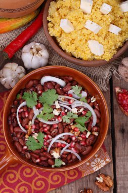 Bir kırmızı şarap ve peynirli polenta ile Nar ile Lobio fasulye servis