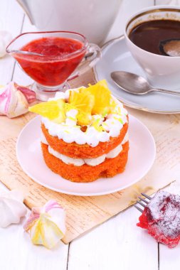 Beyaz ahşap zemin üzerinde kahve ile turuncu kek