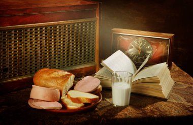 Still life with cooked sausage,baton,radio and clock  clipart