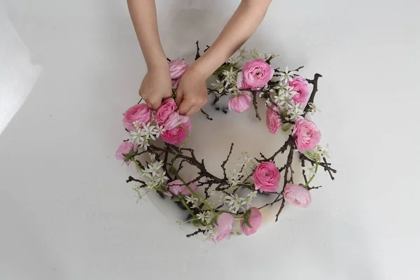 Детские руки возятся с розой в венке — стоковое фото