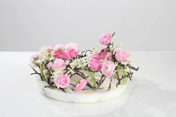 Věnec z růžových růží a jarní květy na bílém pozadí — Stock fotografie