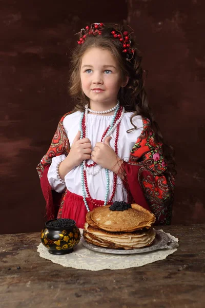 Κορίτσι Στη Ρωσική Στολή Και Τηγανίτες Μαύρο Χαβιάρι Ξύλινο Τραπέζι — Φωτογραφία Αρχείου