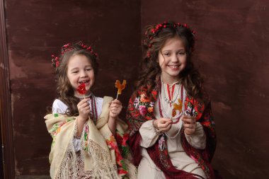Kızlar Rus elbiseler gülmek ve lolipop tutun