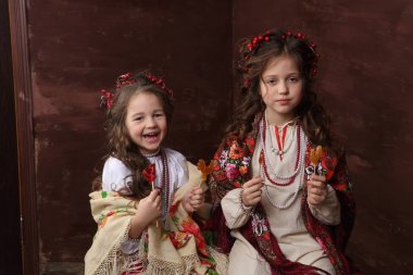 Kızlar Rus elbiseler gülmek ve lolipop tutun