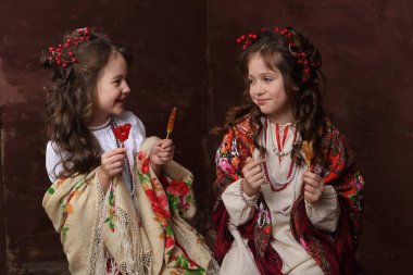 Kızlar Rus elbiseler gülmek ve lolipop tutun