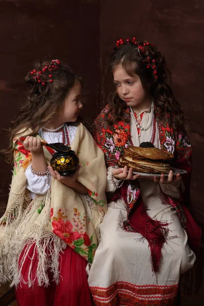 两个穿着漂亮俄罗斯服装的女孩留着煎饼 — 图库照片
