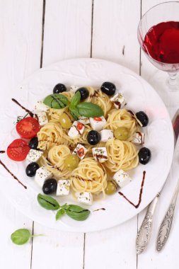 Spagetti ile beyaz peynir. Beyaz peynir, zeytin, domates ve kırmızı şarap ile spagetti