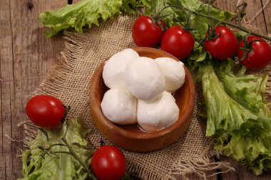Marul, ahşap bir masaya kiraz ile mozzarella
