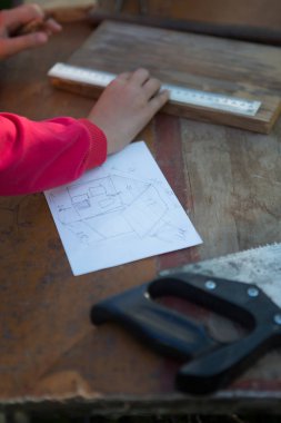 Robot resme göre kız bebek için bir ev inşa ediyor.