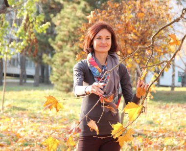 Güz parkında güzel bir kız Ağacın yanında