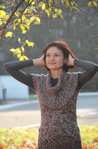 Girl in a brown sweater in the autumn park